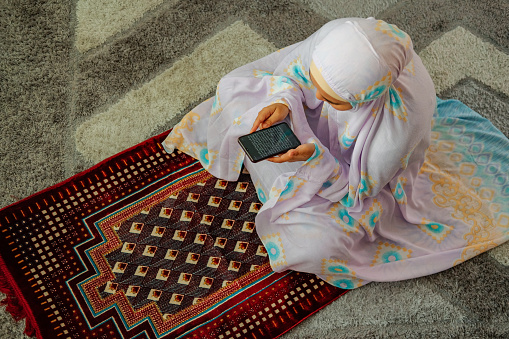 Muslim family using mobile at home during ramadhan